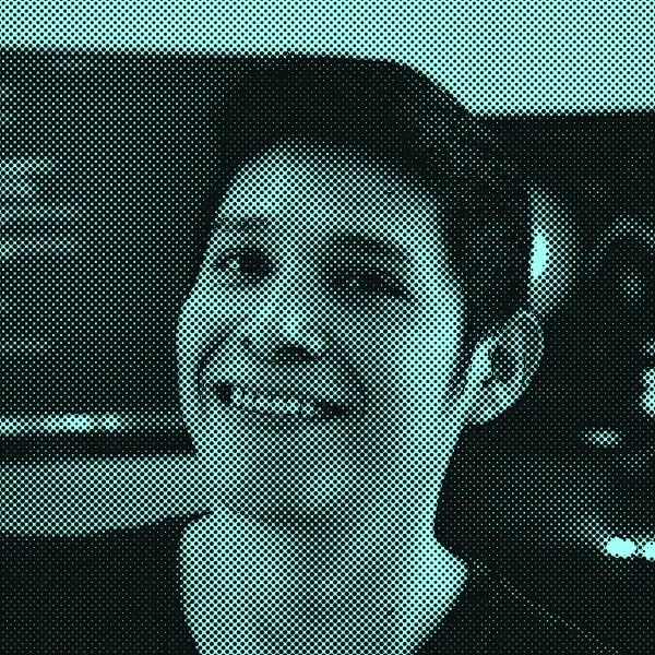 Halftone illustration of Roger Bacab smiling in front of a monitor with code